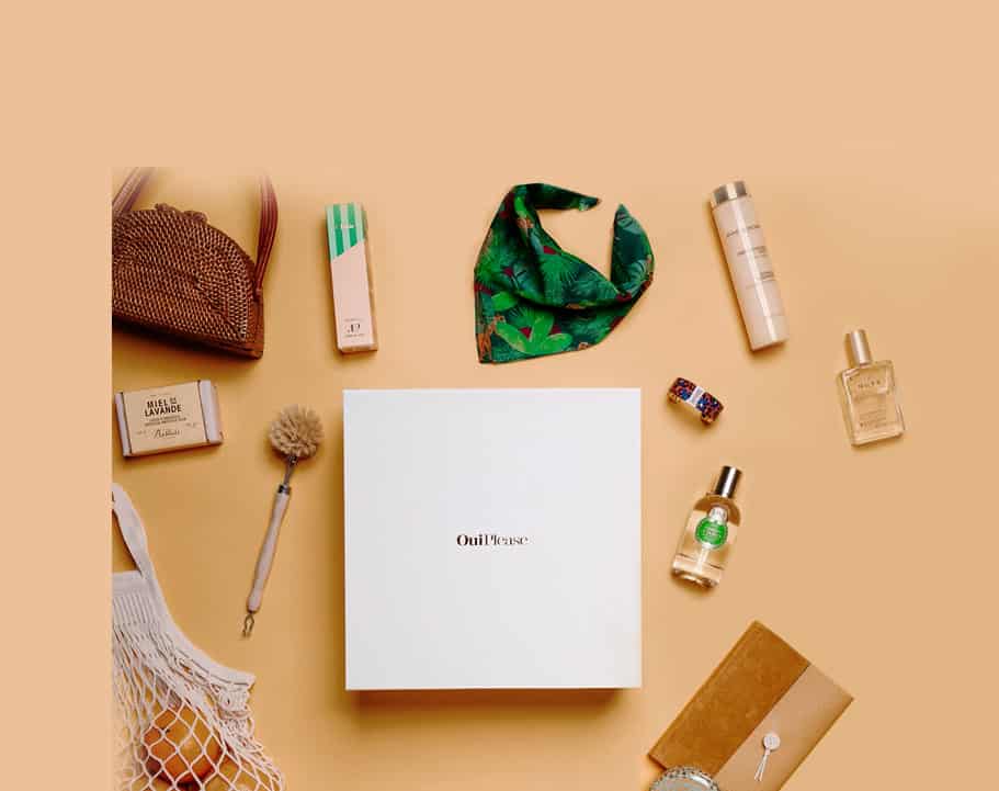 sliders7OP Closed OuiPlease box orange background displaying products around silk scarf, dish brush, agenda, body oil, perfumes