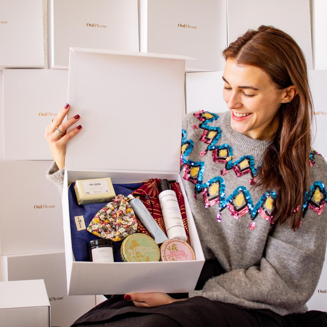 Woman holding open OuiPlease Box